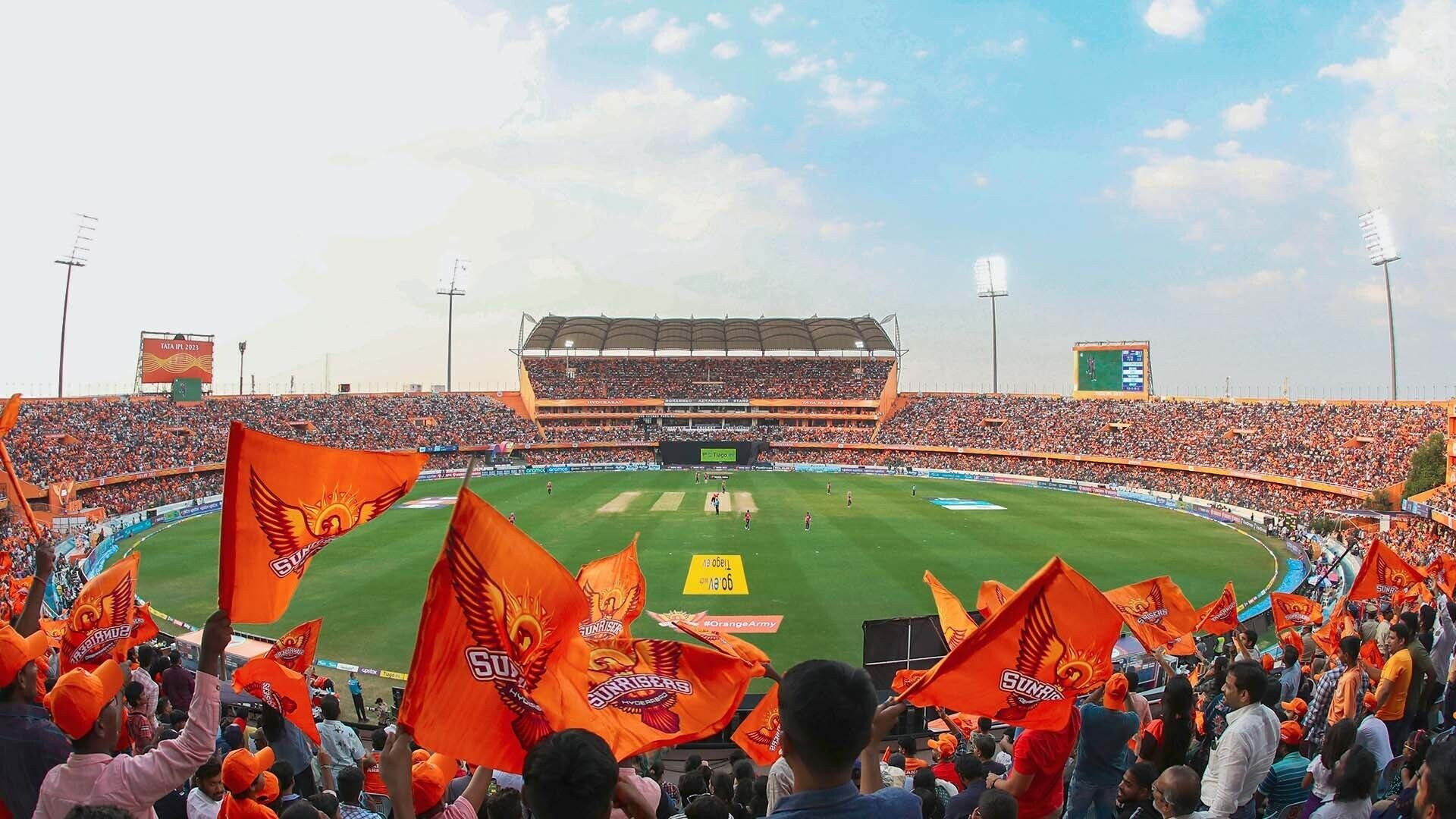A packed stadium of Sunrisers Hyderabad fans waving orange flags